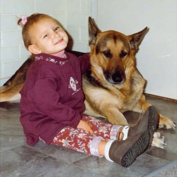 A photo of a little girl with a German Shepherd dog