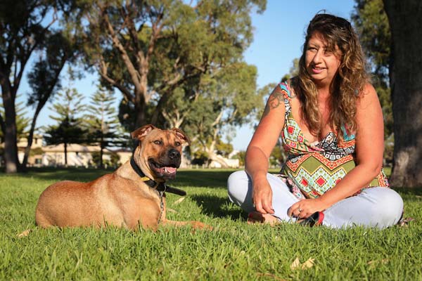 Woman sitting with a dog in a park