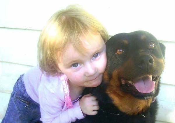 A photo of a young girl hugging a dog