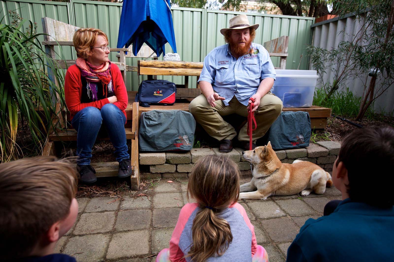 A male ranger giving a talk to a group of children